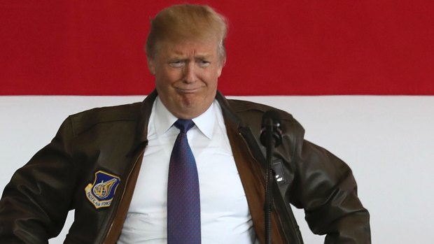 US President Donald Trump puts on a military jacket as he meets the US troops at the US Yokota Air Base, as part of his Asian tour.