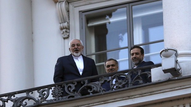 Iranian Foreign Minister Mohammad Javad Zarif, left, talks to journalists from a balcony of the Palais Coburg hotel in Vienna.