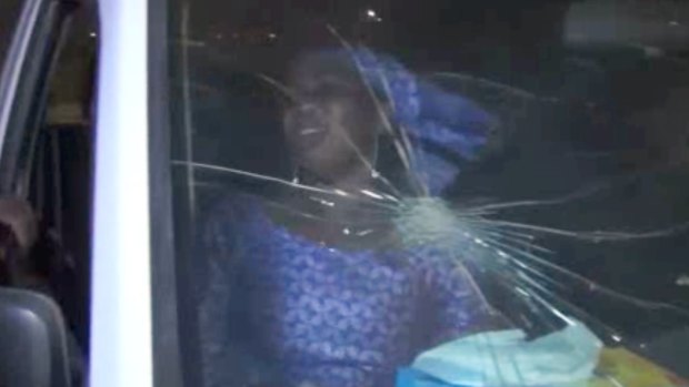 A rescued woman sits in a vehicle with bullet hole in its windshield near the Splendid Hotel in Ouagadougou. 