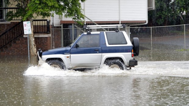 A car driving through flood waters in Brisbane last year