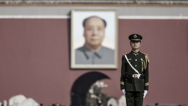 A member of the People's Armed Police stands guard in front of a portrait of former Chinese leader Mao Zedong at Tiananmen Gate in Beijing. China has indicated a continued slowdown in defence spending growth this year, as President Xi Jinping presses ahead with a sweeping military overhaul.
