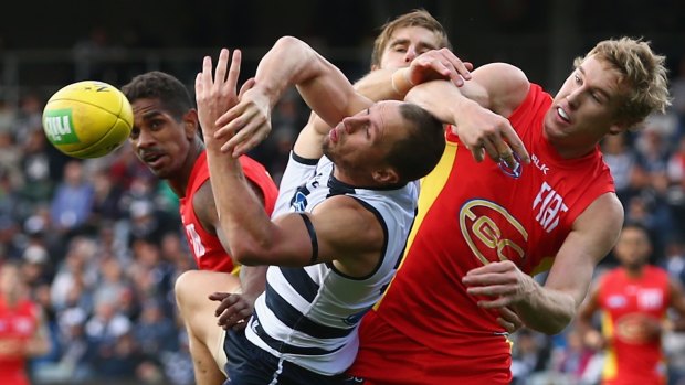 James Kelly of the Cats and Tom Lynch of the Suns challenge each other for the ball.