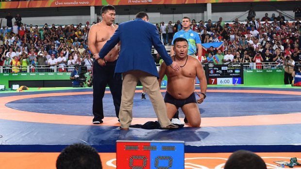Mongolia's coaches protest the judges decision.