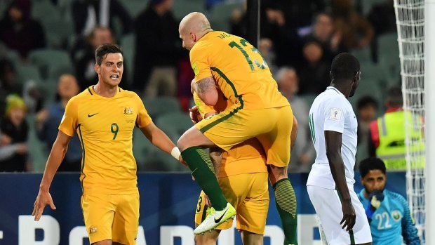 Socceroos Tomi Juric, Aaron Mooy and Tomas Rogic a celebrate after scoring a goal against Saudi Arabia earlier this month.