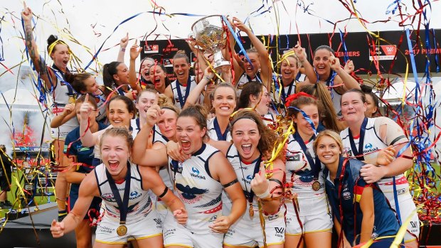 Victors: Adelaide players celebrate with the premiership cup. 