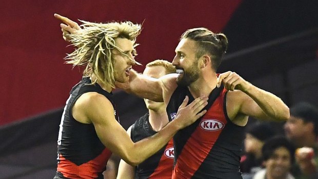 Cale Hooker (right) celebrates a goal with Dyson Heppell.