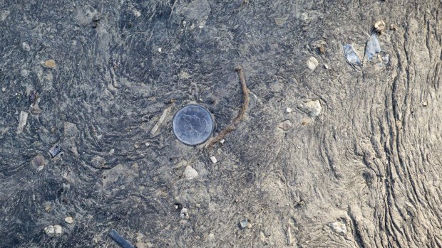 A Canadian dollar embedded in raw oil sands in Fort McMurray, Alberta.