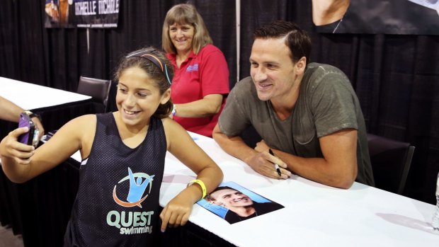 New look: Ryan Lochte is photographed by a young fan at Wizard World Comic Con in Virginia at the weekend.
