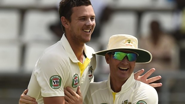 Australia captain Michael Clarke (right) congratulates Josh Hazlewood on his wicket of the West Indies' Darren Bravo.