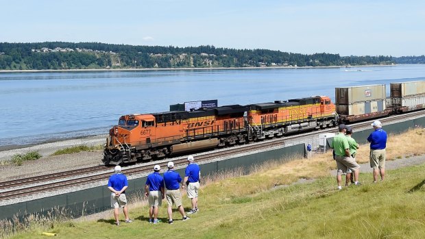 On track: Volunteers look on as a train passes the 17th hole during a practice round prior to the start of the 115th US Open at Chambers Bay.