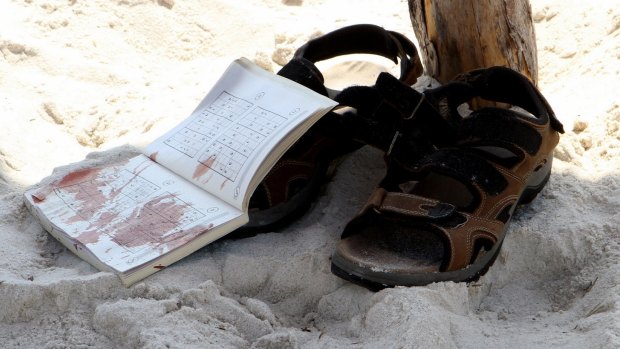 The bloodstained belongings of a tourist on the sand.