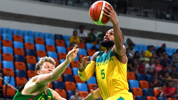 Patty Mills scores against Lithuania.