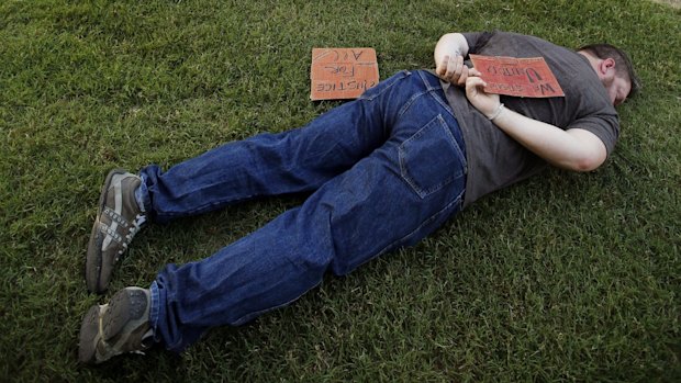 A silent protestor laid in the grass similar to the14-year-old African-American girl who was pinned to the ground by McKinney Police Cpl. Eric Casebolt.