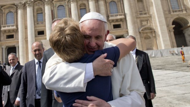 Pope Francis hugs a young boy at the end of his weekly general audience in St Peter's Square on Wednesday.