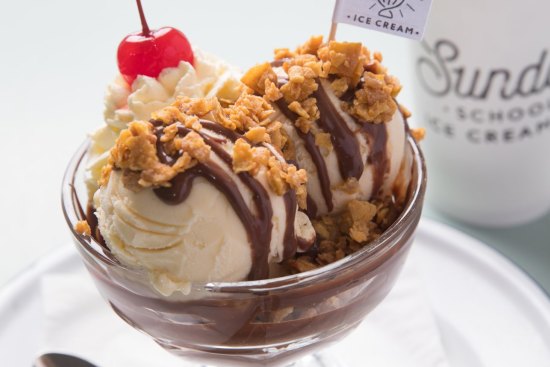 Ice-cream sundae with brown butter peanuts and salted chocolate fudge.