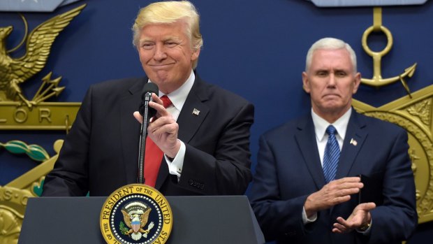 Donald Trump speaking at the Pentagon. Vice President Mike Pence applauds.