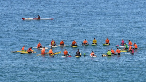 Friends paddled into the ocean off Tamarama Beach and threw sunflowers into the waves.