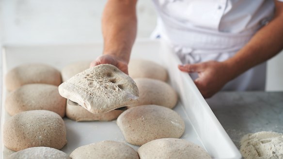 Shaping the base step 3: Lift the dough ball from the tray and turn bottom side up, revealing the bubbles.