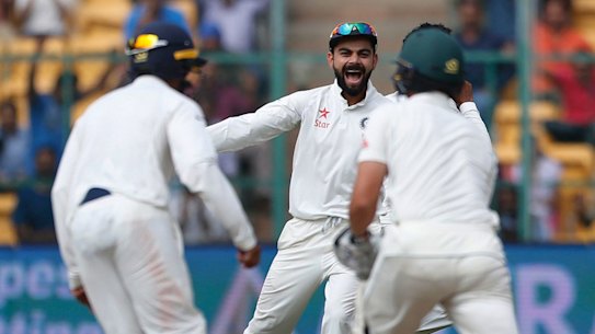 Sniffing victory: Under fire India captain Virat Kohli  celebrates the dismissal of Australia's Steve O'Keefe.