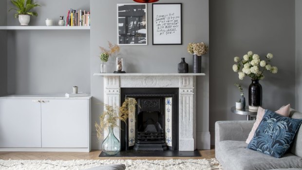 The family room has a Scandinavian-style interior emphasising comfort. The pendant light is from Tom Dixon, and the art above the mantelpiece is a product of House Curious.