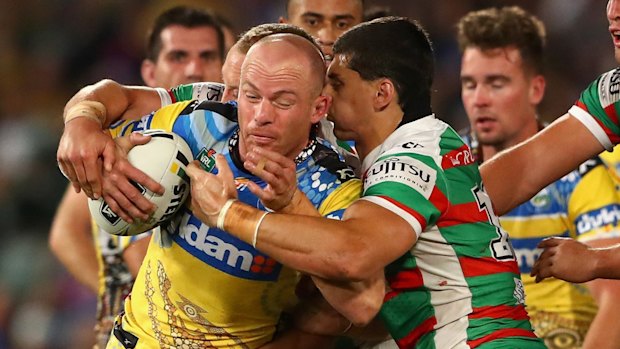 Beau Scott of the Eels is tackled by the Rabbitohs defence.