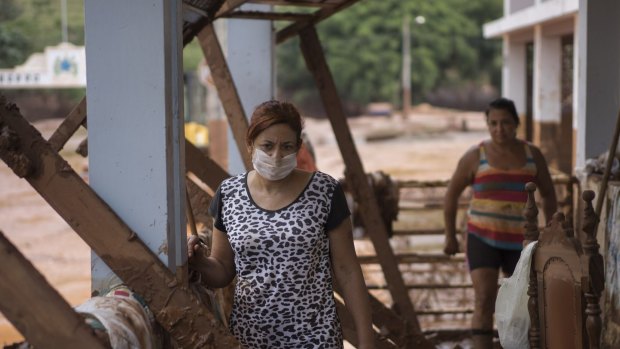 People stand in their damaged home in Barra Longa after a dam burst on Thursday in Minas Gerais state, Brazil.