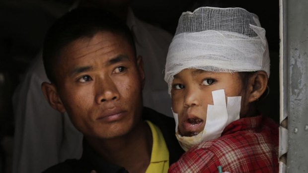 A child injured in Saturday's earthquake, is carried by a Nepalese soldier after being evacuated as they wait to disembark from an Indian Air Force helicopter at the airport in Kathmandu, Nepal.