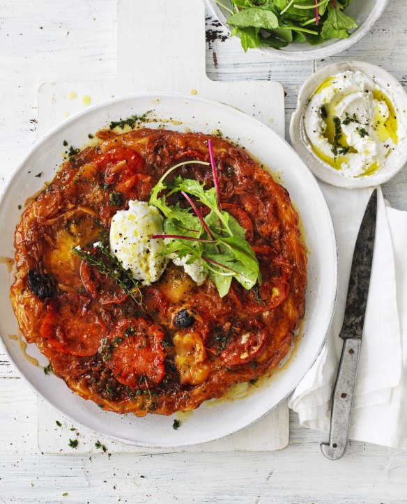 Tomato tarte tatin served with goat's curd and salad leaves.