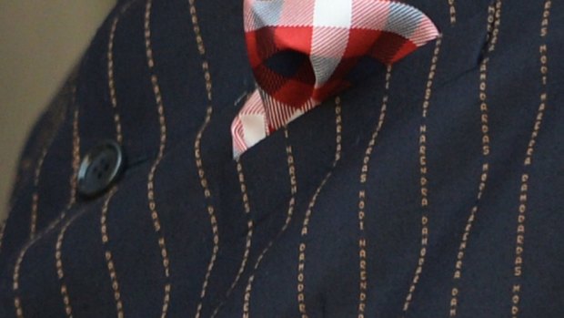 A close-up of the suit detail, with the gold pinstripes bearing his name. 