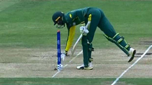 South Africa's Jiveshan Pillay picks the ball up to return it to the fielding side.