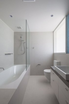Mindful of costs: This en suite has a bath, shower, built-in vanity with a stone top and porcelain ceramic floor tiles. 