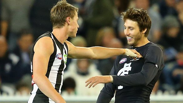 Tom Langdon of the Magpies gives Dale Thomas of the Blues a shove.