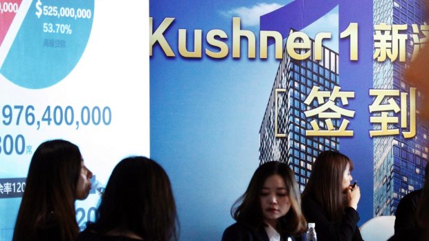 Staff wait for investors at a reception desk during an event promoting investment in a Kushner Companies development in China.