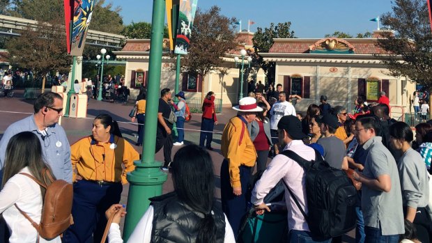 In this photo provided by Dan Greenspan, Disneyland park workers stop people from approaching the entrance.