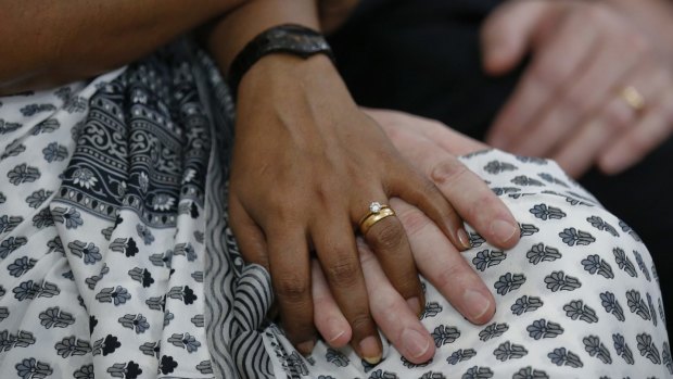 A couple holds hands during a service for Dhaka victims on Monday.