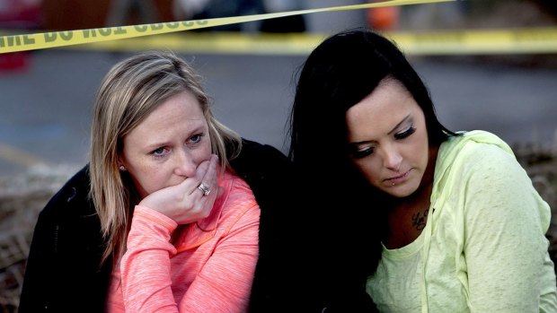 Churchgoers were left reeling from the shooting. Amanda Padula, left, and Deborah Young sit outside Altar Church in Coeur d'Alene, where pastor Tim Remington was shot.