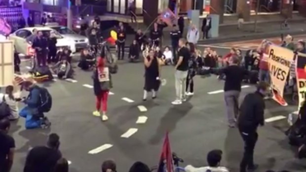 Demonstrators chant at the intersection of King Street and Elizabeth Street in the Sydney CBD.