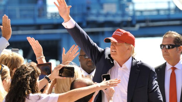 Republican presidential candidate Donald Trump waves as he makes his way to the stage in Florida on Saturday.