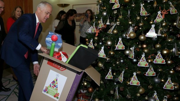 Prime Minister Malcolm Turnbull sorting Christmas presents under the tree in his office at Parliament House.