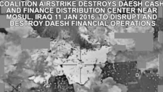 This image made from a video released by the US military shows an air strike targeting an Islamic State group cash and finance distribution centre near Mosul, Iraq.