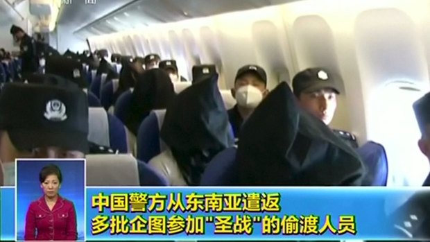 Uighurs deported from Thailand to China last week are dressed in black hoods.