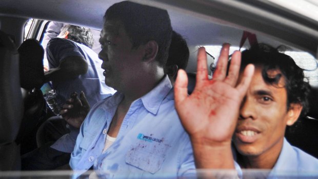 A Jakarta taxi driver has blood on his shirt after being struck by protesters against the Uber public transport app.