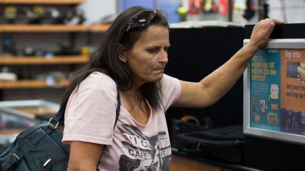 Gail Nielsen pawns a laptop at Hock 'n' Shop pawnshop.