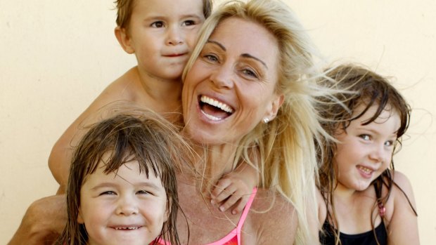 Susie Maroney with her children River, Capri and Paris at Cronulla Beach in 2014.