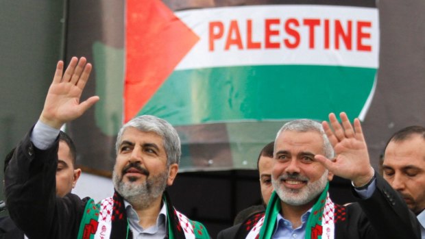Hamas chief Khaled Meshaal, left, and then Hamas leader in Gaza Ismail Haniyeh wave to Palestinian Hamas supporters at the 25th anniversary of the militant group  in Gaza in 2012.