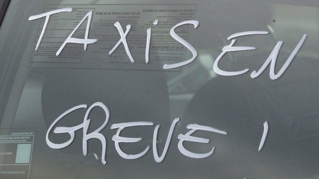"Taxi on strike" is written on a cab during a blockade by taxi drivers in Paris on Tuesday.