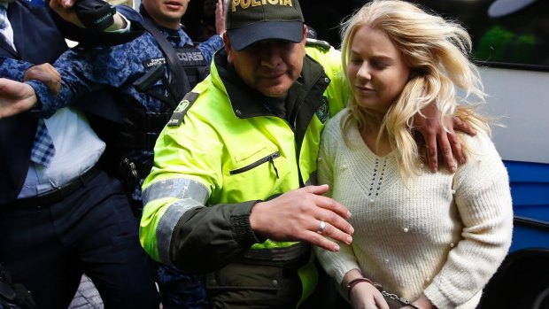 A Colombian police officer escorts Cassandra Sainsbury into court in August.