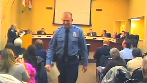 In this February 2014 image, police officer Darren Wilson (centre) attends a city council meeting in Ferguson.