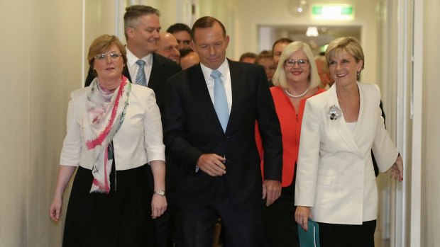 Tony Abbott is flanked by his ministers and loyal MPs as he arrives for the party room meeting on Monday. 
