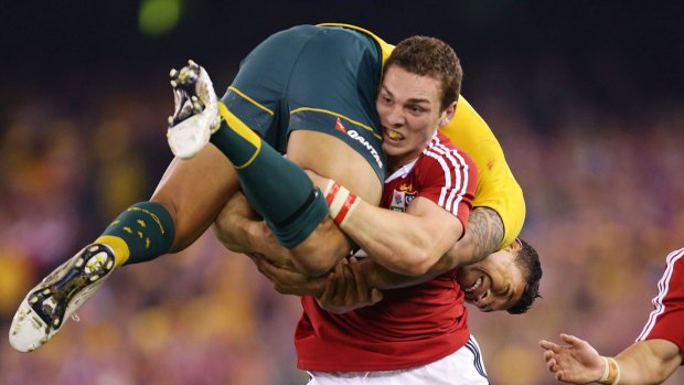 Carry on: George North lifts Israel Folau during the Australia v Lions Test last year.